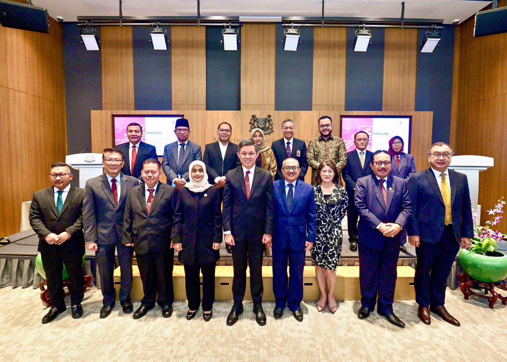 Group of seven people in business attire, standing beneath the "ERBER Group" logo and monitors showing produce.